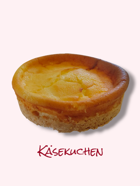 Ein goldbrauner Käsekuchen mit glatter, cremiger Oberfläche auf hellem Hintergrund.