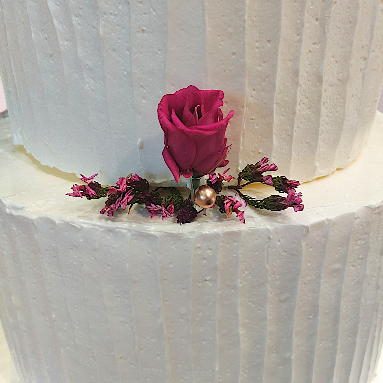 Eine weiße Torte mit Rillen mit einer glatten weißen Creme und dekorativen Zitronenscheiben, sowie Olivenzweige