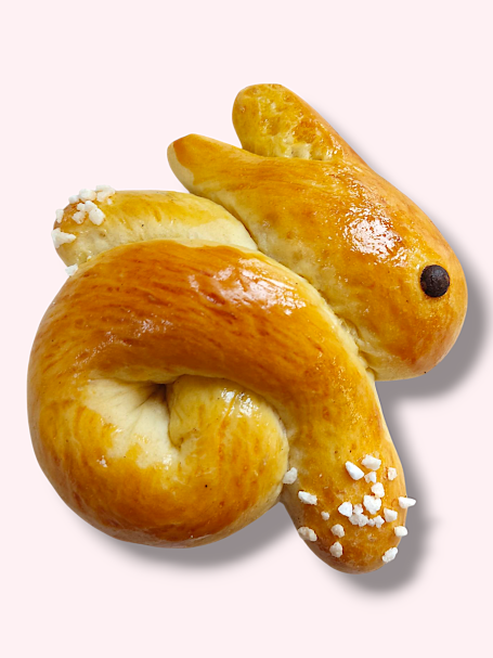 Ein süßer Hefeteig in Form eines Hasens, goldbraun und mit Zuckerkristallen bestreut.